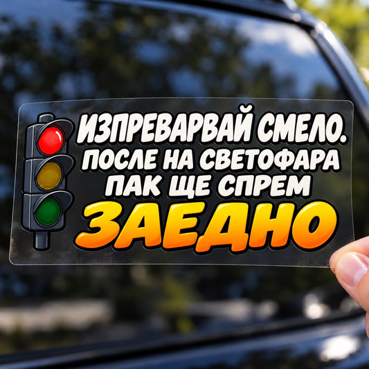 Стикер Изпреварвай смело върху плоско прозрачно транспортно фолио, държан с ръка пред размазан автомобилен фон